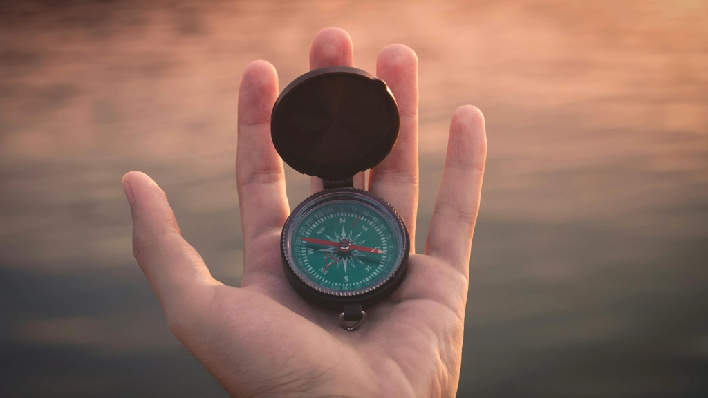 Image: Hand holding a compass